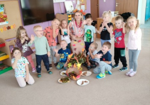nauczycielka przebrana w jesienny stój pozuje z dziecmi do wspólnego zdjęcia