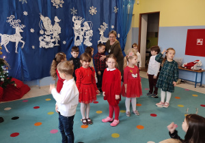 nauczycielka ustawia grupę dzieci do wystepu