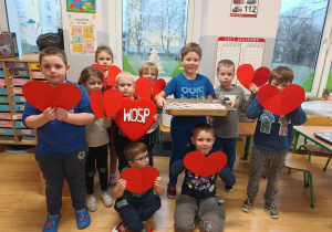 grupa dzieci z mufinkami i serduszkami z kartonu pozuje do wspólnego zdjęcia
