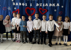 grupa dzieci ubrana odświętnie występuje z okazji Dnia Babci i Dziadka