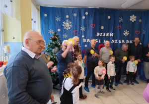 grupa dzieci i dziadków we wspólnej zabawie w szatni , dziadkowie mają przypięte do piersi medale
