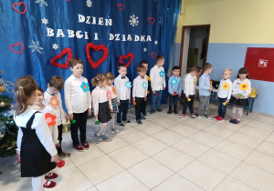 grupa dzieci ubrana odświętnie występuje z okazji Dnia Babci i Dziadka