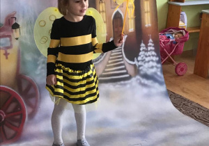 dziewczynka przebrana za pszczółkę pozuje do zdjęcia
