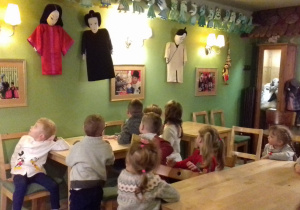 dzieci oglądają rekwizyty teatralne wiszące na ścianach