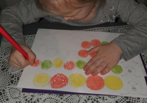 dziewczynka koloruje rytmy na matematycznej gąsienicy