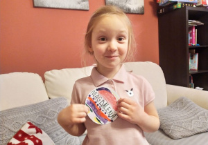 dziewczynka prezentuje znaczek astronauty, który wykonała