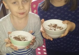 dziewczynka i chłopiec pokazują swoje hodowle fasolek
