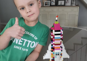 chłopiec prezentuje rakietę wykonaną z klocków lego