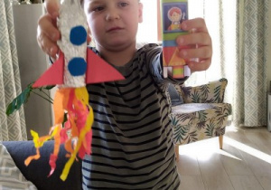 chłopiec trzyma w rękach dwie własnoręcznie wykonane rakiety