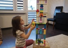 dziewczynka buduje rakietę z klocków