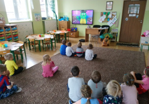 grupa dzieci ogląda film edukacyjny o segregowaniu śmieci
