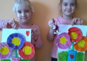 dziewczynki prezentują wykonane przez siebie wiosenne bukiety