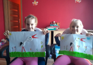 dziewczynki prezentują obrazki z bocianami