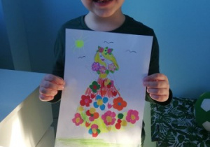 chłopiec prezentuje obrazek z Panią Wiosną