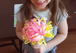 dziewczynka prezentuje wykonany przez siebie wiosenny bukiet