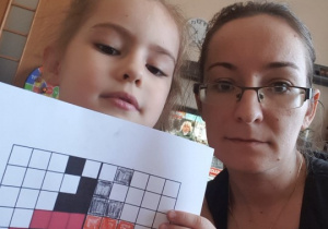 mama i córka pokazują kartę pracy kodowaną biedronkę