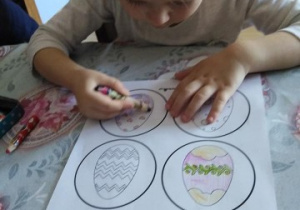 dziewczynka koloruje obrazki z pisankami