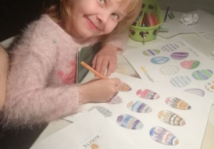 dziewczynka koloruje obrazki z pisankami