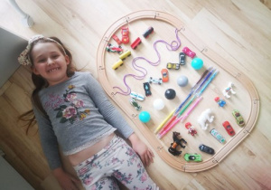 dziewczynka pokazuje wykonaną "pisankę" z zabawek