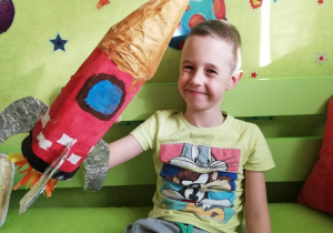 chłopiec pokazuje wykonaną przez siebie rakietę