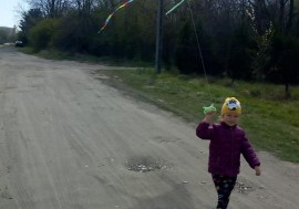 dziewczynka biegnie z latawcem