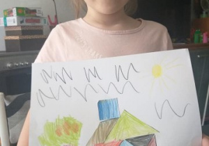 dziewczynka pokazuje domek wykonany z tangramu