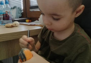 chłopiec maluje pisankę