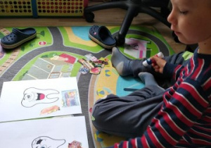 chłopiec pracuje na kartach z obrazkami zebów