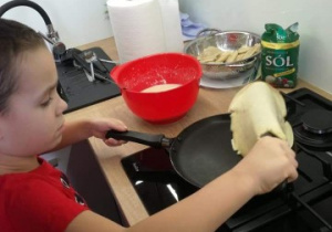 chłopiec przygotowuje w kuchni potrawę