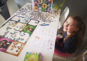 dziewczynka układa puzzle