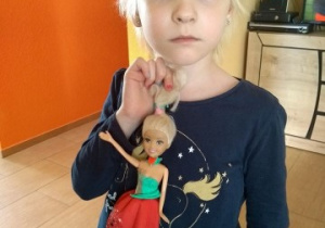 dziewczynka trzyma w dłoni laleczkę