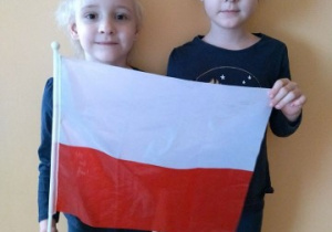 dwie siostry stoją z biało-czerwoną flagą