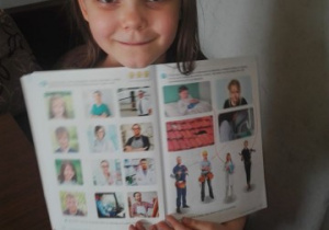 dziewczynka pokazuje swoję przedszkolną książkę