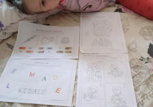 dziewczynka pokazuje wykonane karty pracy
