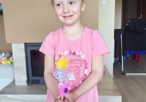 dziewczynka prezentuje wykonaną różdżkę do rozśmieszania rodziców