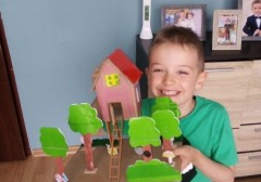 chłopiec pokazuje makietę domku i drzew