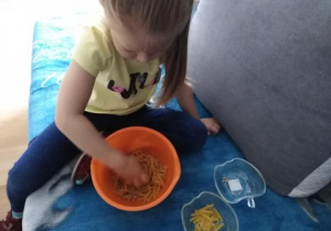 Dziewczynka bawi się makaronem