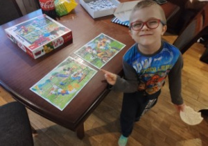 Chłopiec pokazuje ułożone puzzle