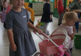 dziewczynka z grupy Biedronki stoi z wózeczkiem dla lalek