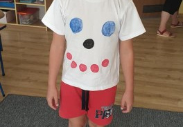chłopiec prezentuje koszulkę w kropki, które układają się w "uśiech"