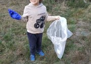 chłopiec pokazuje śmieci zebrane w lesie