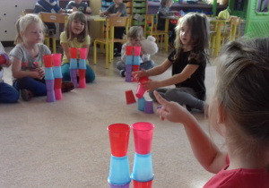 dzieci układają wieże z kubków wg wzoru