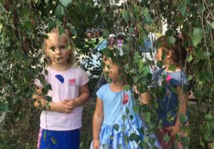 trzy dziewczynki stoją pod drzewem