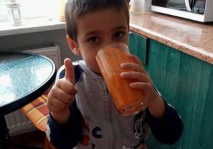 chłopiec pije sok owocowy, który przygotował