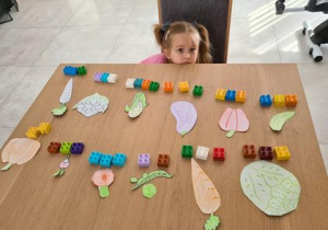 dziewczynka prezentuje wykonane prze siebie zadanie "sylaby warzywne"