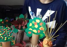 chłopiec prezentuje wykonane prace plastyczne - drzewa z rolki i ziemniaczane ludziki