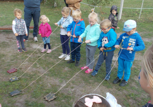 dzieci nawijają drewniane żółwie na sznurkach