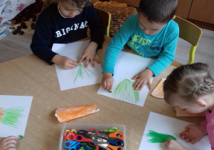 dzieci kreślą zieloną pastelą wiązkę z punktu