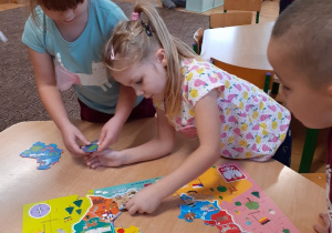 dwie dziewczynki układają puzzle przedstawiające mapę Polski