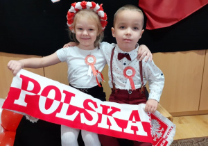 chłopiec i dziewczynka z szalikiem "POLSKA" pozują do zdjęcia